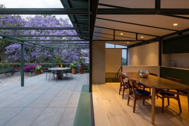A modern apartment with a courtyard that connects to open glass doors.