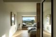 A hallway leading to a bedroom with a large window.