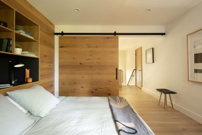 A bedroom with a sliding wood door.