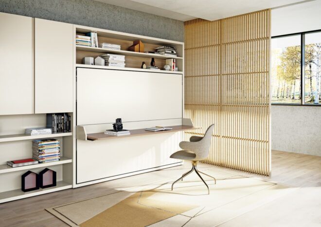 A wall area that has a pull down desk and chair with a partition screen
