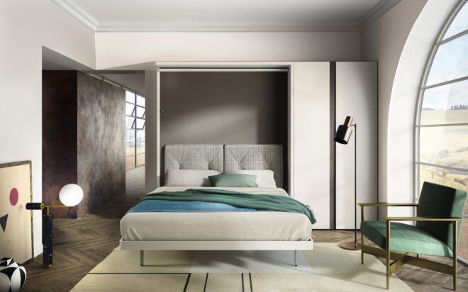 A bedroom with a large window on the right and a bed that is pulled down from the wall