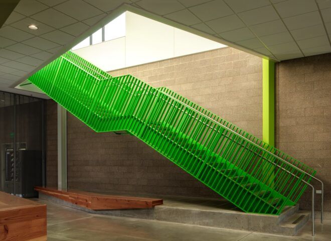 A green staircase set against a wooden wall