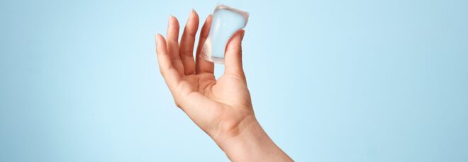 A hand holding a clear Notpla packet