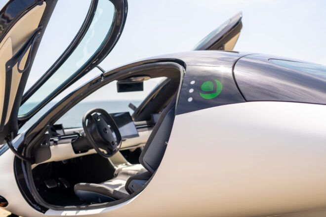 A white Aptera car with the door open.