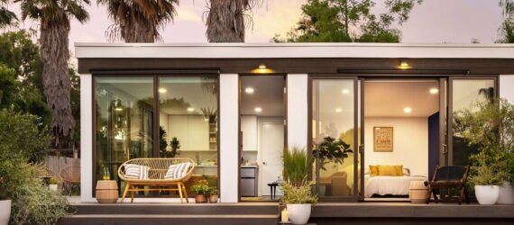 A one-story house that has steps leading up to it and open windows all around