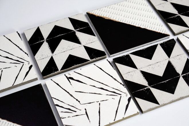 Different tiles laid down, each has a black and white pattern to it