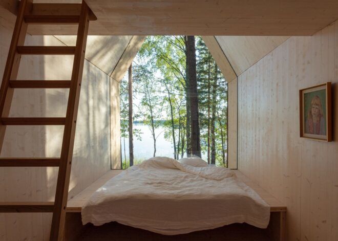 A bed with a staircase at its foot and a large opening toward the forest