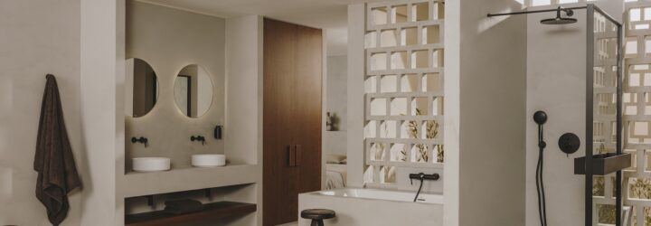 A white bathroom with an area to hang a bathrobe and a white bathtub