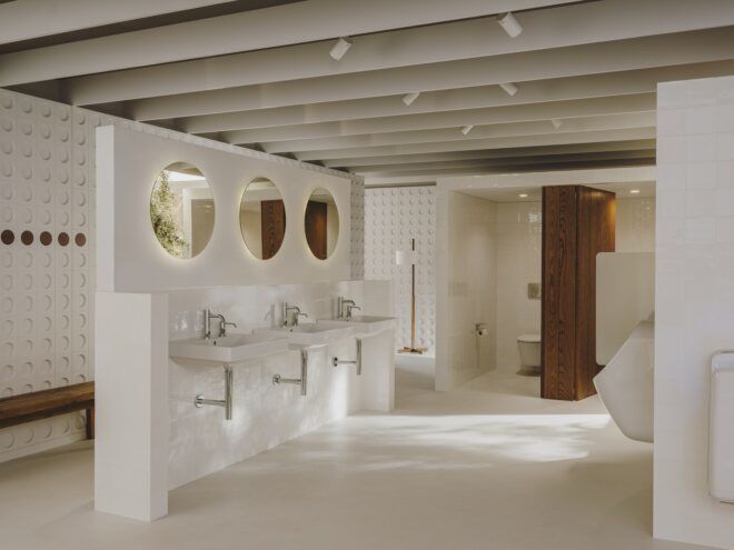 Three sinks with three circle mirrors above them