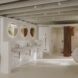 Three sinks with three circle mirrors above them