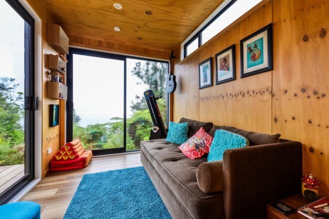A sofa facing a window with frames above the sofa