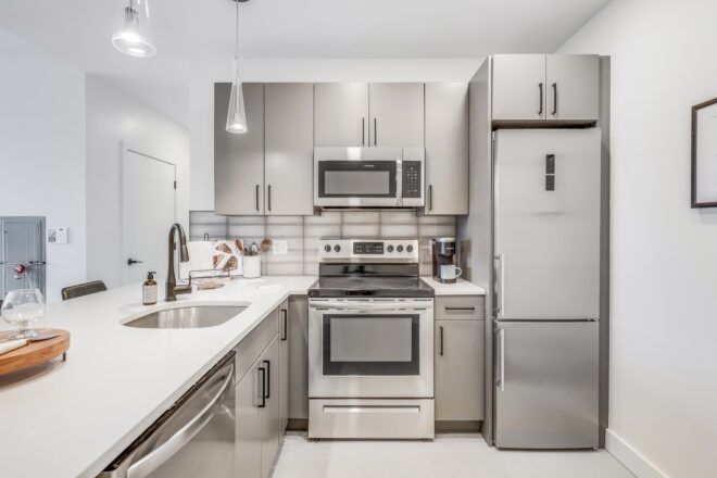 A kitchen filled with LEED energy efficient stainless steel refrigerator, sink, oven and microwave