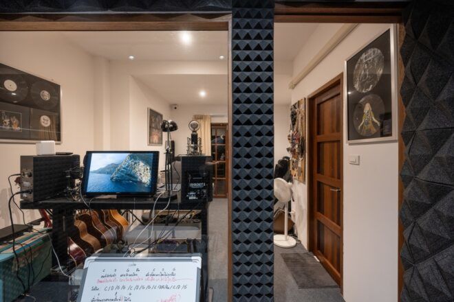 A music studio with a laptop sitting on a stand and a score of music