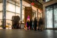 A straw covered rectangle structure called the Feelings Library with people standing in a line outside of it
