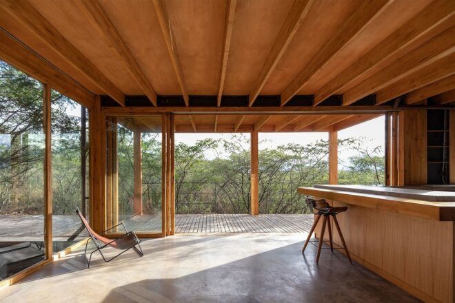 A room that overlooks the forest outside with a island on the right side