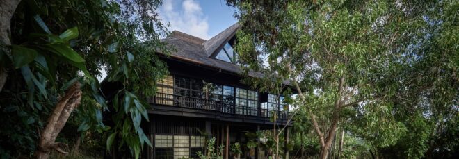 A wooden house called The Barn designed by Alexis Dornier sits in a forested area
