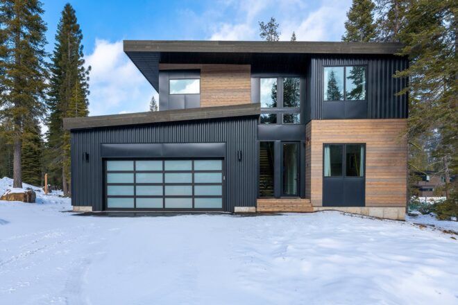 A two story house with a garage in a snowy area