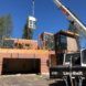 A machine lifting parts of the house to assemble the house