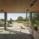 A living room open to a deck area where a dog lays down.