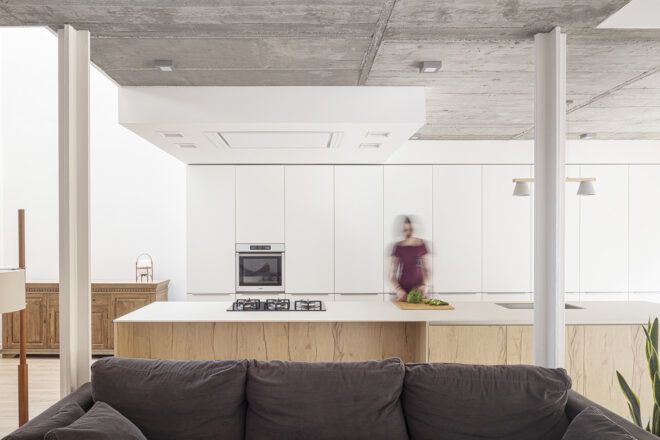 A blurry figure in a white kitchen.