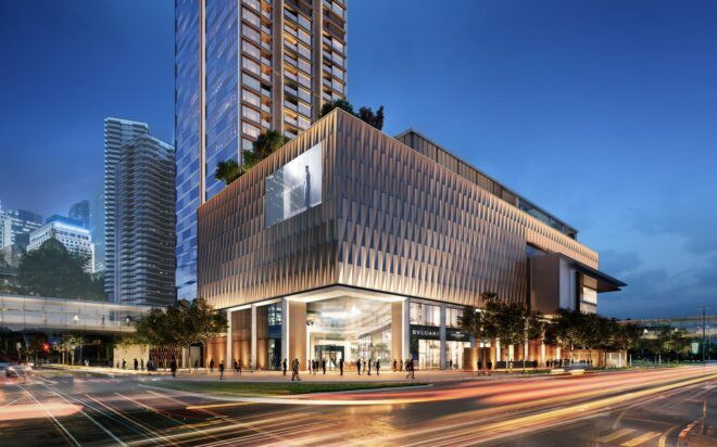 A square building sitting next to a skyscraper on a busy city street