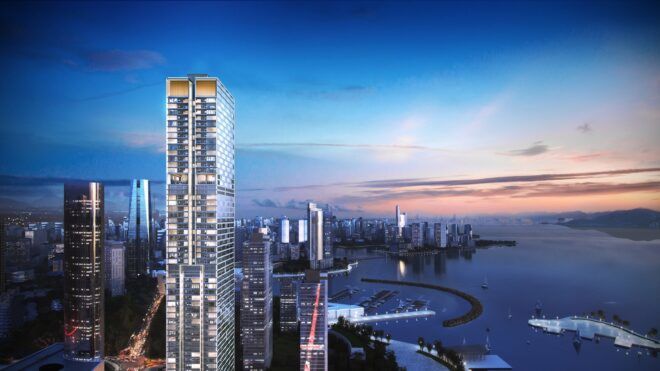 A tall skyscraper in China amidst other skyscrapers sitting beside a river