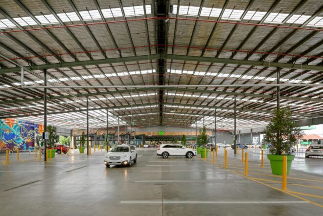 A large industrial parking lot that leads to a supermarket