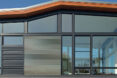 The exterior of a home with many glass walls.