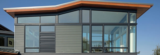 The exterior of a home with many glass walls.