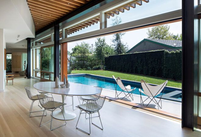 An open dining area that looks out on a pool.