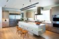 A kitchen with white counters and wood floors.