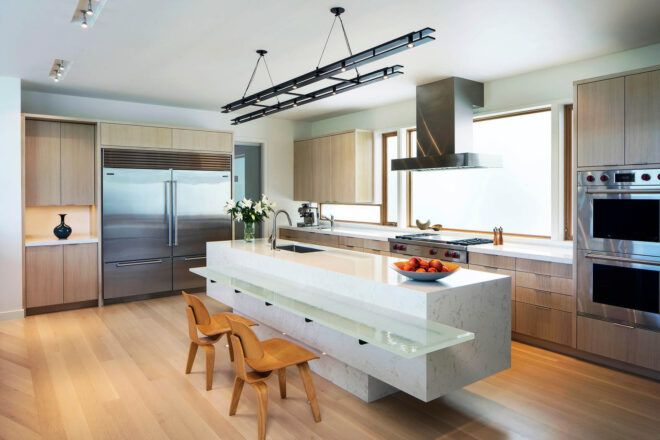 A kitchen with white counters and wood floors.