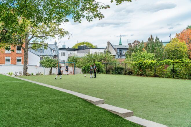 A grass area where there are young kids playing