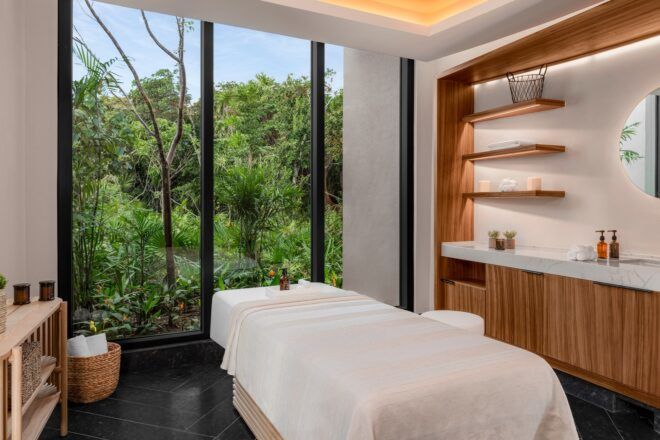 A bed and spa equipment set in front of a floor-to-ceiling
