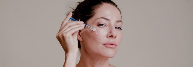 A women holding up the stem cell serum onto her cheek
