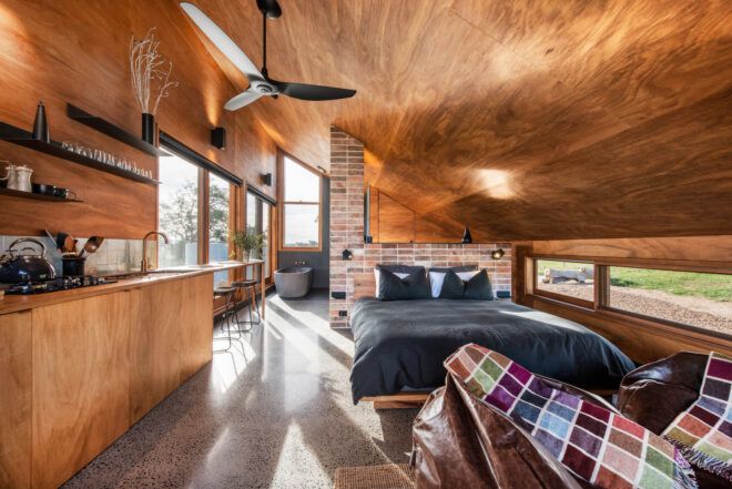 The interior of a wood home with a dark blue bed.