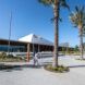 A long building with palm tress that are planted in front of it