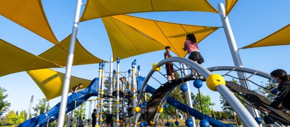 A playground that is covered by yellow triangle overhangs