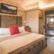 Interior of the chalet with a large bed and door to the bathroom in the background