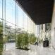 A lobby with glass walls and plants inside.