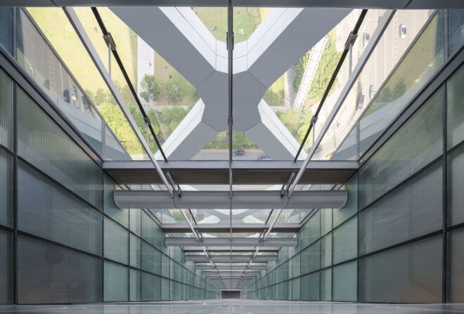 A view looking down a glass corridor.