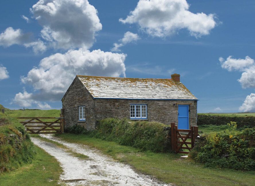 A rustic cottage on a green countryside.
