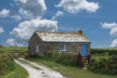 A rustic cottage on a green countryside.