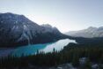 A mountain range with a lake running in the middle and a forest on the edge of it