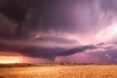 A dry plains landscape with a stormy and cloudy sky