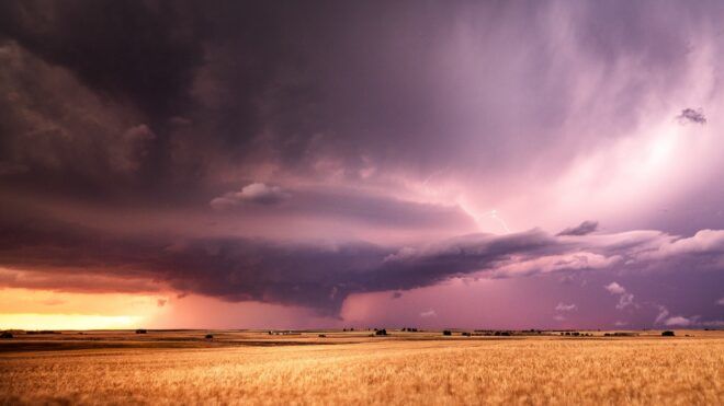 A dry plains landscape with a stormy and cloudy sky