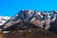 A mountain range with a few spots of snow