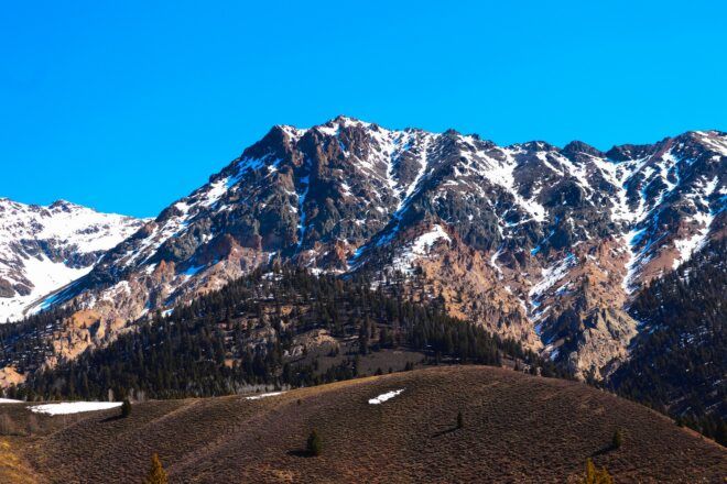 A mountain range with a few spots of snow