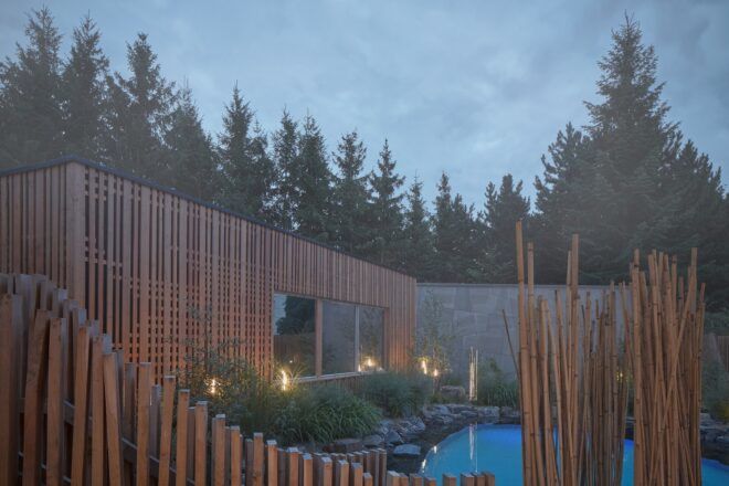 A wooden building faces a wellness pool