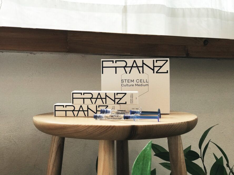 White packaging with the words Franz across it all sitting on a wooden stool
